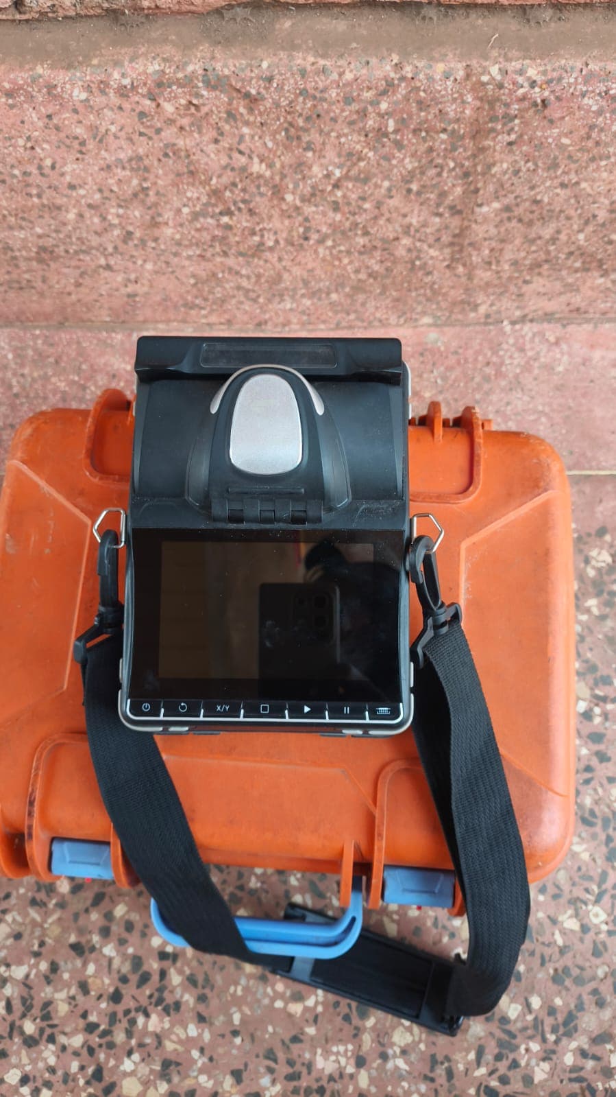 Open fusion splicer positioned on its orange protective field case